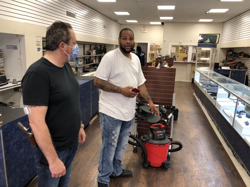 Pawnbroker Scott Lee Cohen, left, and his employee Robert Ross recount the May 31 break-in at the pawn shop at 90th and Commercial.