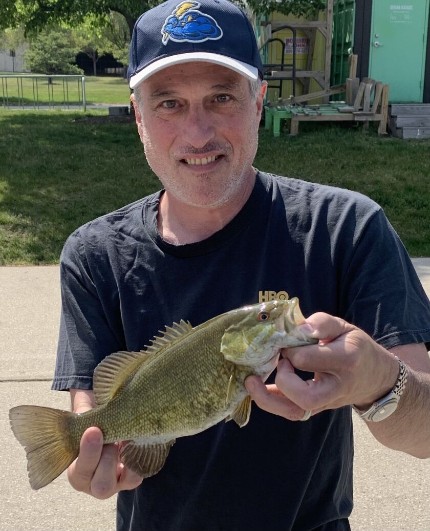 Dan Bernstein, midday host on The Score, holds a smallmouth bass caught on an ultralight from the Chicago River. Provided photo