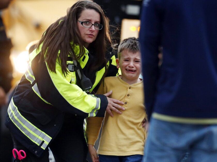 Officials guide students off a bus and into a recreation center where they were reunited with their parents after a shooting at a suburban Denver middle school Tuesday, May 7, 2019, in Highlands Ranch, Colo. (AP Photo/David Zalubowski)