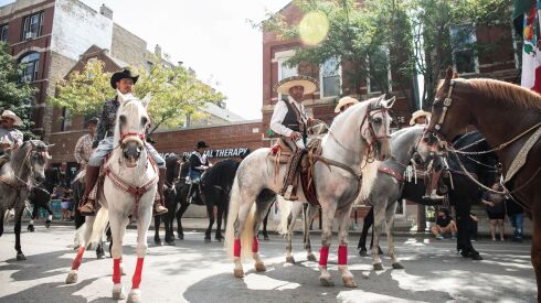 Men riding horses march down West 18th Street in the Pilsen neighborhood during the 20th annual Mexican Independence Day Parade, Saturday afternoon, Sept. 10, 2022.