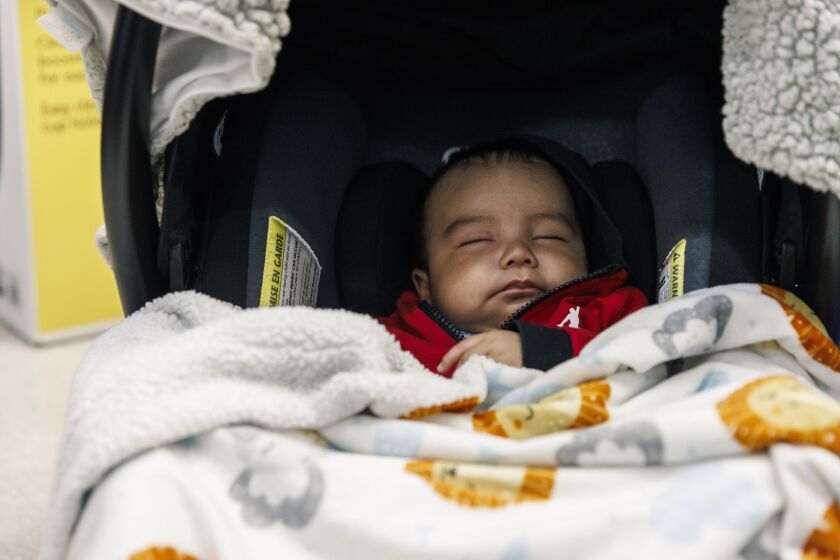 Lizzet Gonzalez’s son, Ismael, sleeps during a communal baby shower held at the Pilsen offices of community organization El Valor. 