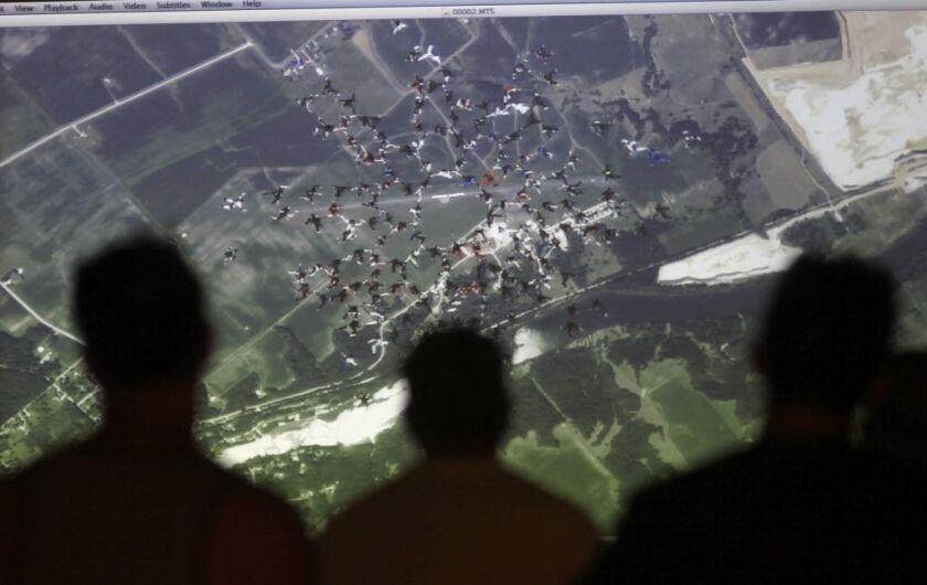 Skydivers watch a video of their skydive shortly after attempting to make a world record jump at Skydive Chicago, Friday, July 31, 2015, in Ottawa, Ill. It took the international team 13 attempts to beat the 2012 mark set by 138 skydivers. | Christian K.