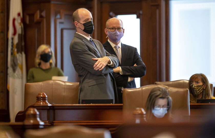 State Senate President Don Harmon, D-Oak Park, right, talks with state Sen. Bill Cunningham, D-Chicago, left, during debate on the energy proposal in the Senate on Monday.