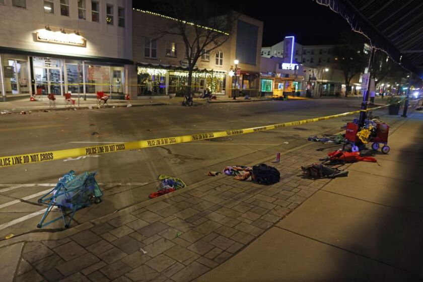 Police tape cordons off a street in Waukesha, Wis., after a vehicle plowed into a Christmas parade hitting more than 20 people Sunday, Nov. 21, 2021.