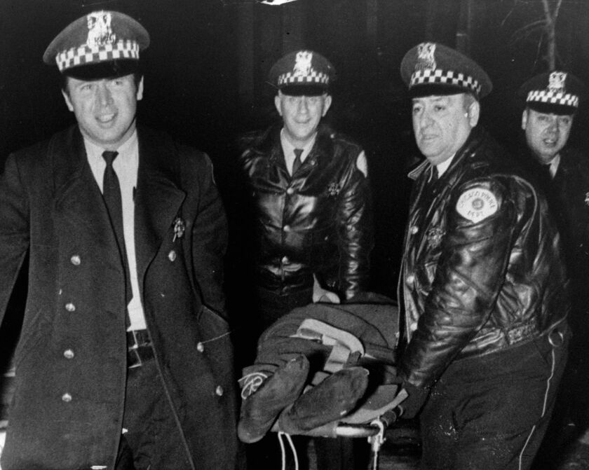Chicago police officers move the body of Fred Hampton after he was shot and killed in 1969.
