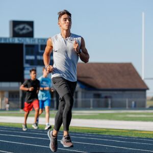 Plainfield South’s Niko Schultz runs around the track to warm up at the start of practice.