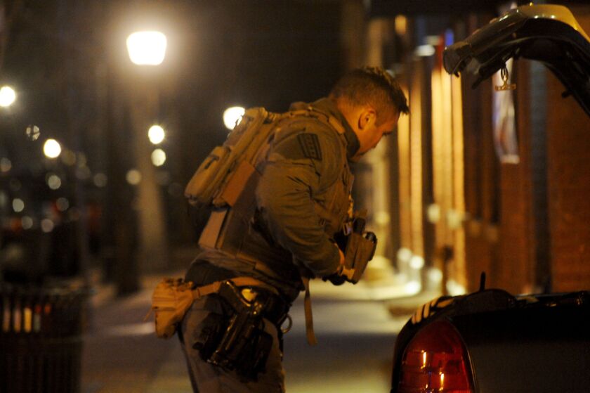 A SWAT officer takes his gear off following a barricade situation Thursday night in the 1400 block of West Taylor. Justin Jackson/Sun-Times