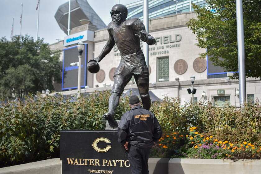 Eddy Bastardo looks up at the Walter Payton statue outside Soldier Field Friday following the announcement of former Bears coach Mike Ditka's death.