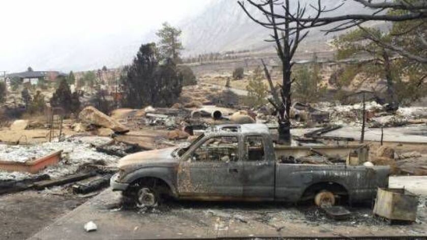 Vehicles are burned and homes are reduced to rubble in the community of Swall Meadows, Calif., Sunday, Feb. 8, 2015. Fire crews increased containment of a wind-driven wildfire that destroyed 40 homes, but they said Sunday that they still didn’t know when