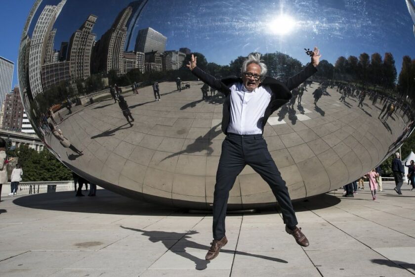 Anish Kapoor jumps for a photo in front of Cloud Gate, his famous sculpture in Millennium Park, on Tuesday, Oct. 17, 2017. | Ashlee Rezin/Sun-Times