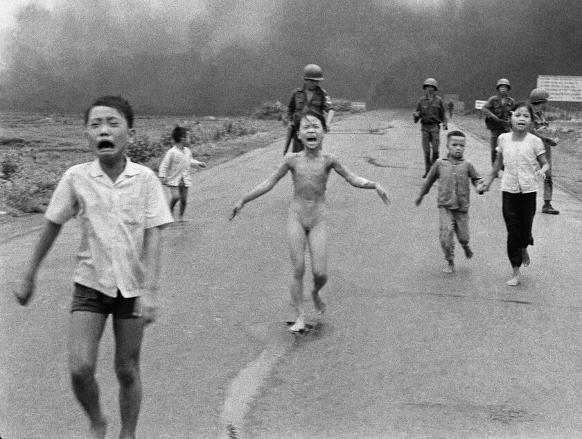 In this June 8, 1972, photo, crying children including 9-year-old Kim Phuc Phan Thi (center), run down Route 1 near Trang Bang, Vietnam, after an aerial napalm attack on suspected Viet Cong hiding places as South Vietnamese forces from the 25th Division walk behind them. A South Vietnamese plane accidentally dropped its flaming napalm on South Vietnamese troops and civilians.