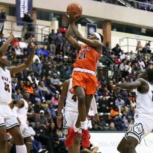 Young’s DJ Steward (21) twists in the air to make a shot against Morgan Park.