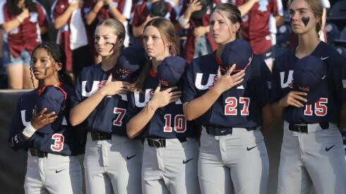 Amira Hondras (left) stands alongside her teammates for the national anthem before the U.S. Women's National baseball team beat Korea's team 22-2 in the Women's Baseball World Cup in Rockford, Wednesday July 22, 2026.