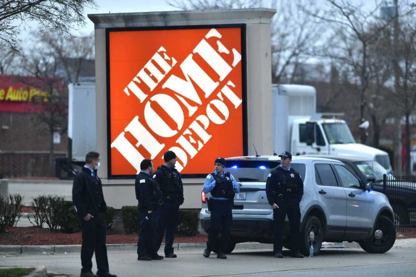 Police officers stand at the scene where an alleged shoplifter shot a security guard and then later shot a CPD officer.