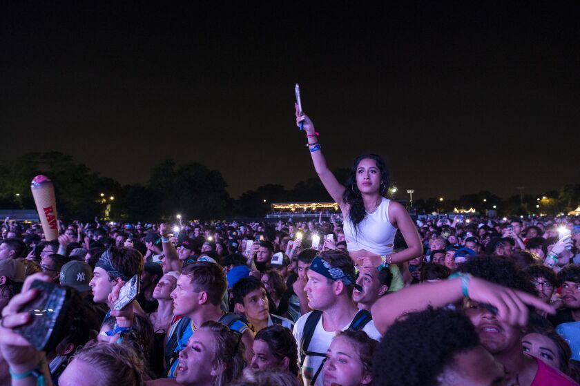 Festivalgoers hold their phones up in the air as Lil Baby performs.