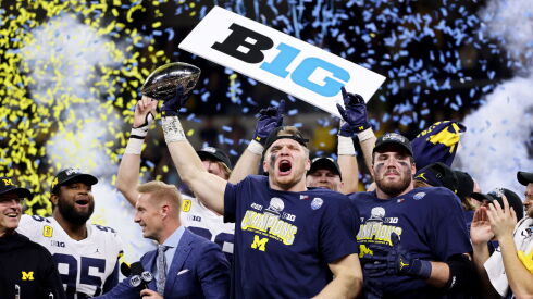 Michigan’s Aidan Hutchinson lifting the trophy after his team won the Big Ten championship.