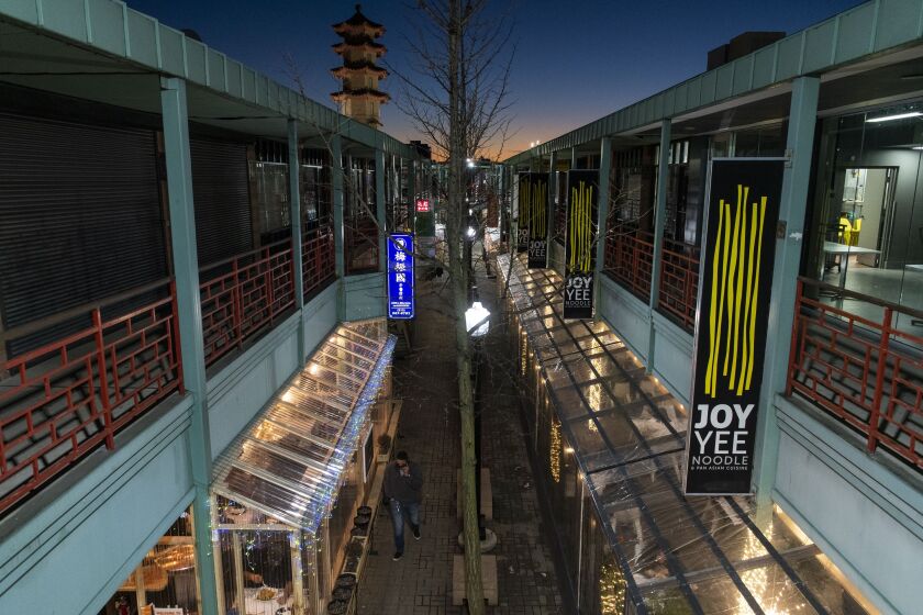A man walks along Chinatown Square’s outdoor mall.