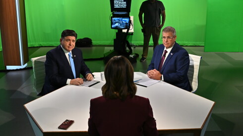 Democratic Gov. JB Pritzker, left, and Republican challenger Darren Bailey sit across from moderator Brandis Friedman, foreground, ahead of the televised WTTW News Gubernatorial Forum on Tuesday, Oct. 13, 2026, at WTTW studios in Chicago.