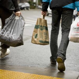 In this Saturday, Jan. 30, 2010 picture, people carry paper and plastic shopping bags in Portland. An Oregon state senator is proposing a bill to ban plastic bags at checkout in Oregon - the first statewide ban in the nation if it passes. Senate President