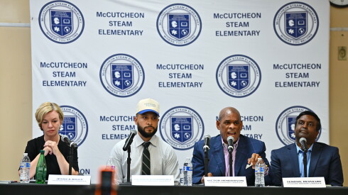 The Chicago Board of Education presidential candidates at a table during a forum in early September: Jessica Biggs, Hilario Dominguez, Victor Henderson and Sendhil Revuluri. Revuluri suspended his campaign on Wednesday.