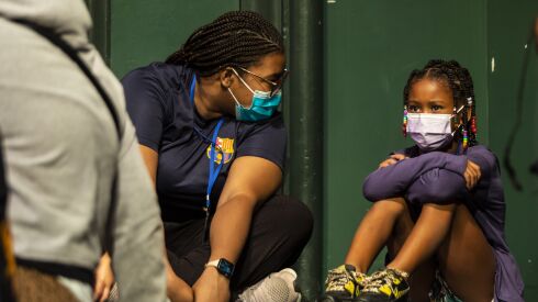 Counselor Kierra Towns, 25, who lost her mother as a child, chats with Mia while other children play during the Hearts to Art summer camp on July 11.