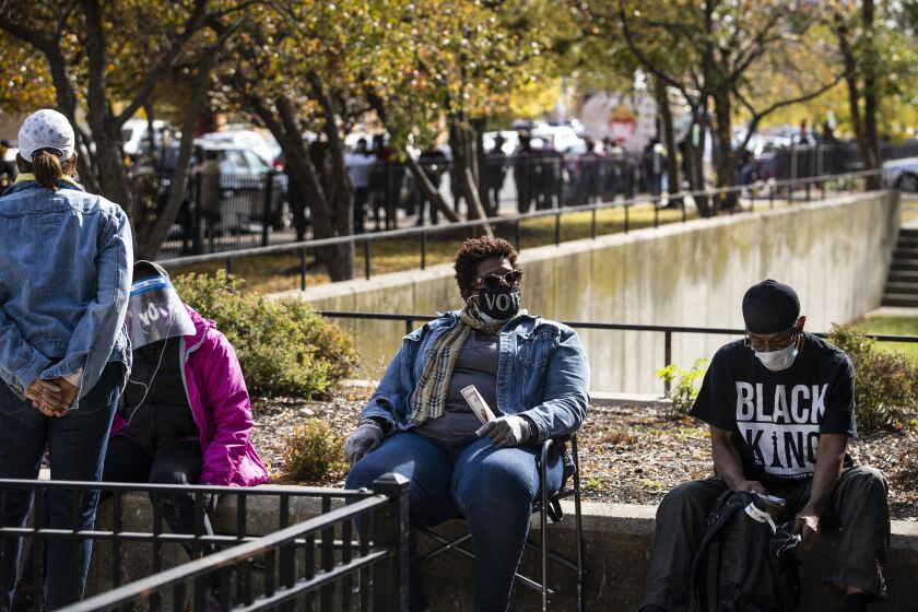 Melvina Lee, center, 56, of Bronzeville, waits in line for more than three hours to early vote in the General Election at the Dr. Martin Luther King Center Service Center in the Bronzeville neighborhood last month.