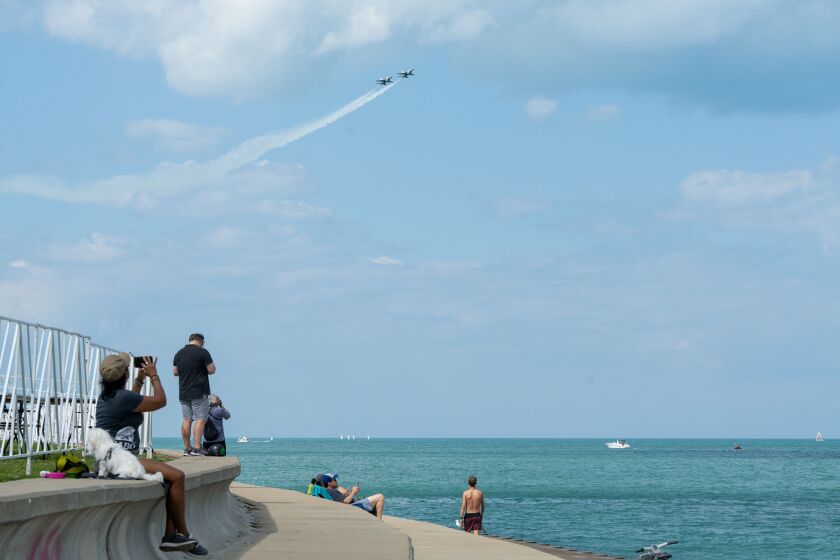 People watch from the lakefront Thursday as U.S. Air Force F-16 Fight Falcons with the Thunderbirds air demonstration squadron practice their routine for the 2023 Chicago Air & Water Show.