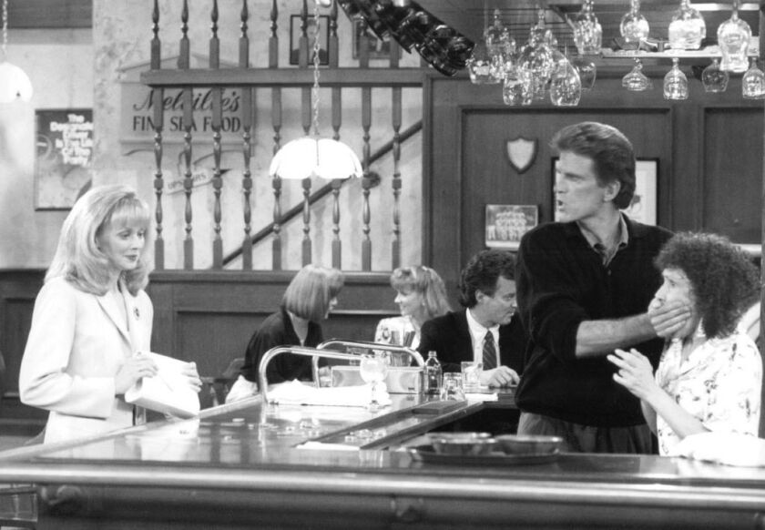 Ted Danson as bartender Sam Malone, Rhea Perlman as waitress Carla Tortelli, and Shelley Long as Diane Chambers on “Cheers.” | NBC File photo