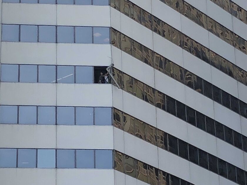 Crews secure a 300-pound beam that was dangling from the 10th floor of 150 N. Michigan Ave. on Tuesday. | Mitchell Armentrout/Sun-Times