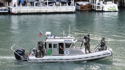 Armed federal agents ride a boat on the Chicago River in the Loop, Thursday, Sept. 25, 2025.
