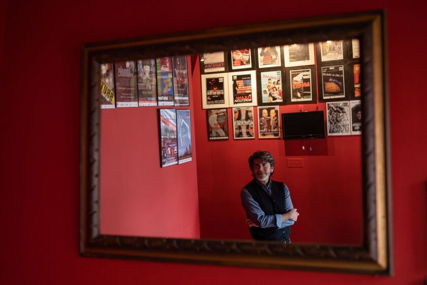 Aguijón Theater’s ensemble member Elio Leturia in front of some of the posters he designed at Aguijón Theater on September 28, 2019. | Pat Nabong/For The Sun-Times