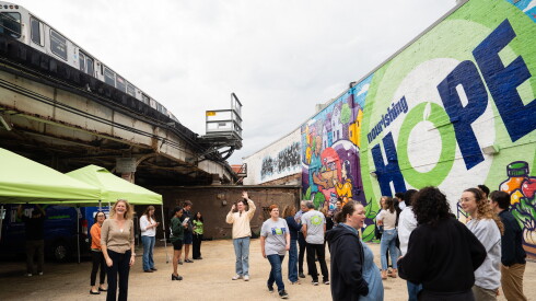 A CTA Red Line train passes by Anthony Lewellen’s “Radiating Hope” mural outside Nourishing Hope’s Sheridan Market location in Lake View.