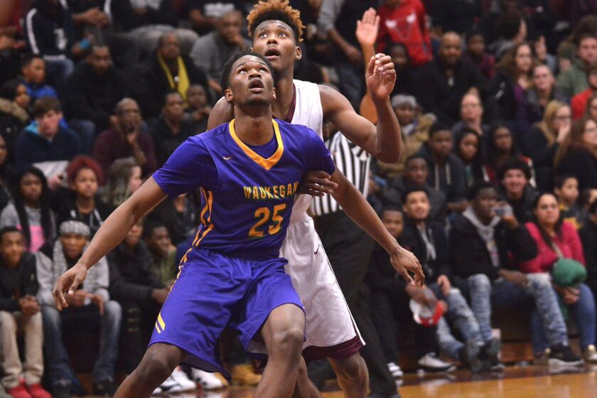 Waukegan’s Bryant Brown (25) backs Zion-Benton’s Joshua Meeks (50) out of the lane. Worsom Robinson/ For the Sun-Times.