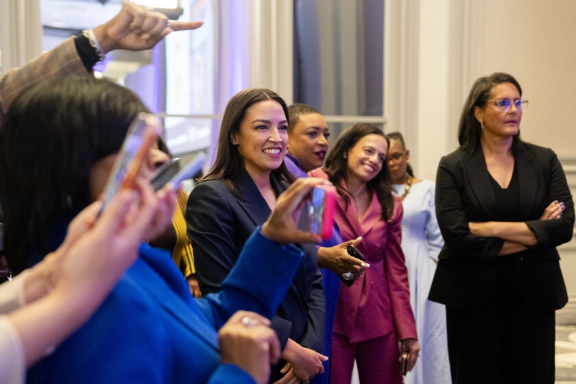 U.S. Rep. Alexandria Ocasio-Cortez smiles as she watches senate candidate and Lt. Gov. Juliana Stratton take pictures with attendees during “Power Rising" at Hilton Chicago in the Loop on April 18.