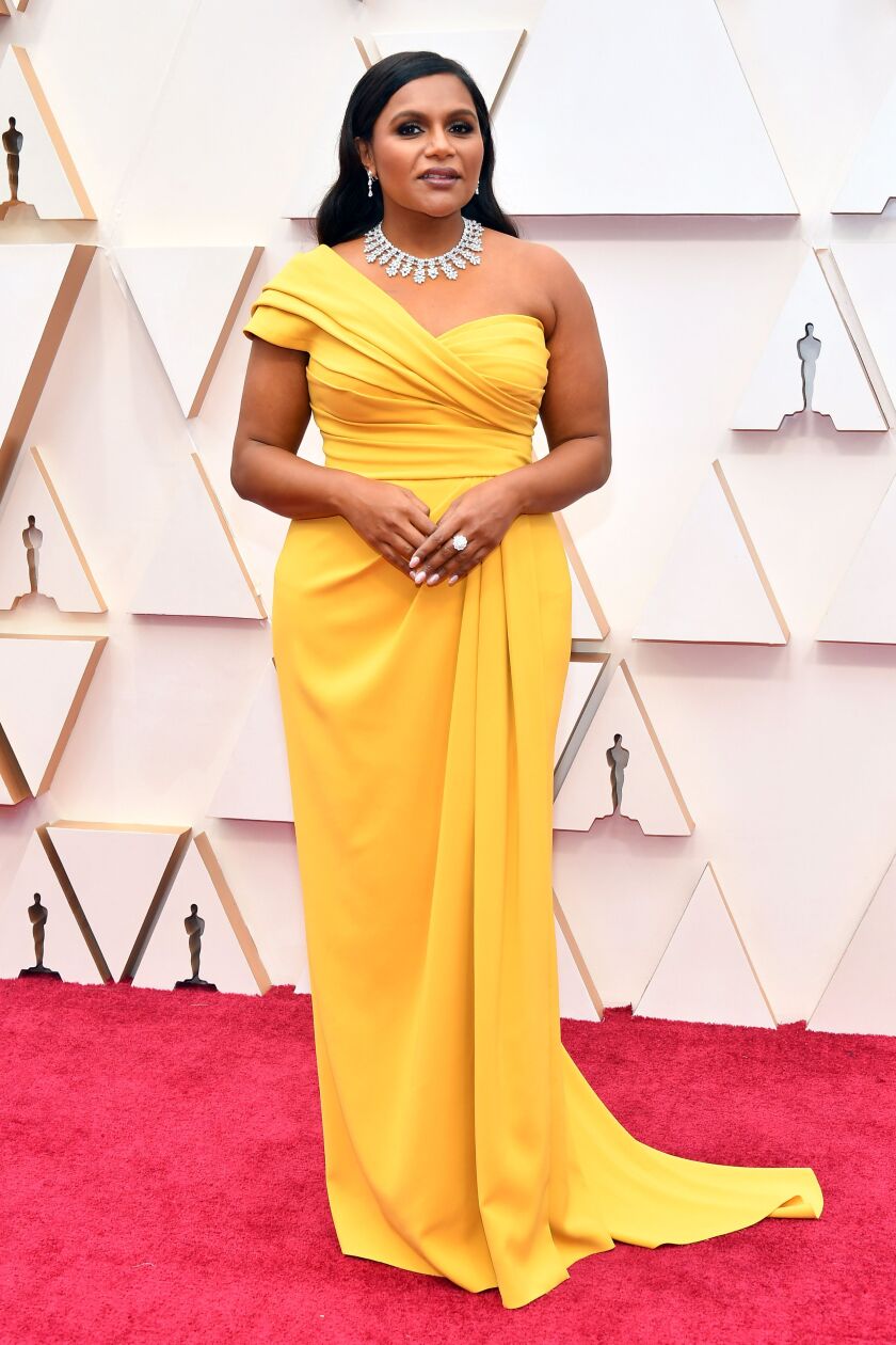 Mindy Kaling attends the 92nd Annual Academy Awards in a yellow Dolce & Gabbana gown.
