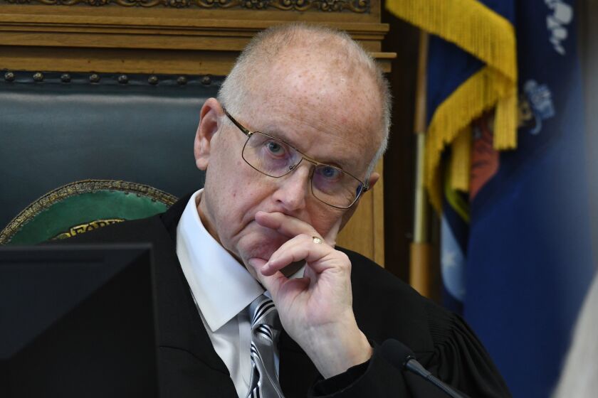 Circuit Court Judge Bruce E. Schroeder listens during the pretrial hearing of Kyle Rittenhouse in Kenosha Circuit Court, Monday, Oct. 25, 2021, in Kenosha, Wis. Rittenhouse shot three people, killing two of them, during a protest against police brutality in Kenosha in August 2020.