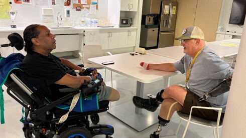Amputee peer mentor Bradley Schwartz, right, talks with amputee Karl Fisher.
