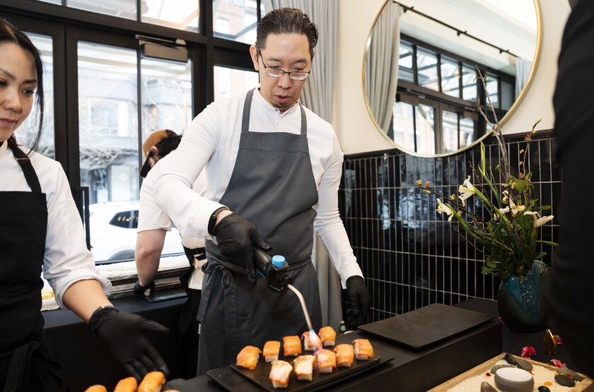 Executive Chef and Partner of Boka Restaurant Group Gene Kato prepares nigiri.