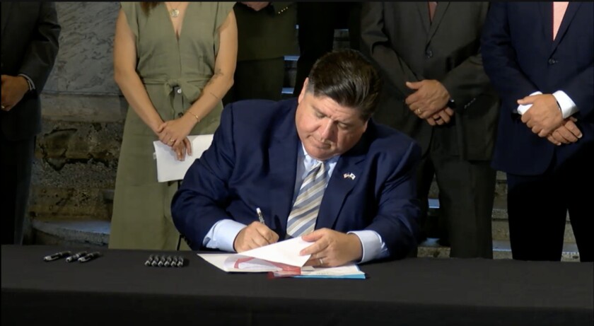 Gov. J.B. Pritzker signs one of the bills designed to protect first responders at emergencies on Thursday.