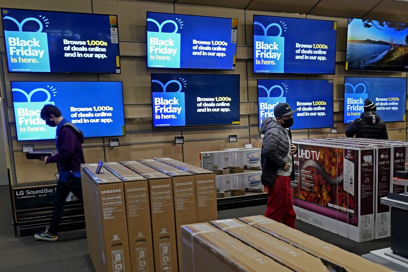 People look at televisions during a Black Friday sale at a Best Buy store Friday, Nov. 26, 2021, in Overland Park, Kan.