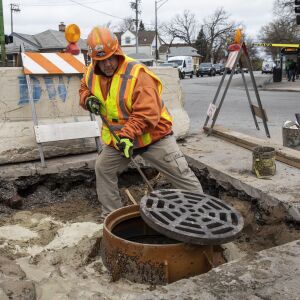 Glenn Kubek of the city of Chicago Department of Water Management places a new catch basin cover — created by Neenah Foundry — on a rebuilt sewer frame at East 93rd Street and South Jeffery Boulevard on the South Side. April 27, 2022.