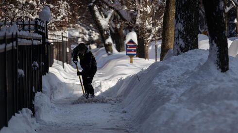 A person shovels snow on the sidewalk in the Edgewater neighborhood, Tuesday morning, Feb. 16, 2021, after a snowstorm dumped over a foot of snow in Chicago starting Sunday night. Snow is expected to continue to fall until Tuesday night. | Pat Nabong/Sun-Times