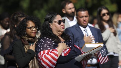 Newly naturalized citizens recite the Pledge of Allegiance during a naturalization ceremony at President George Washington’s Mount Vernon estate on September 23, 2022 in Mount Vernon, Virginia.