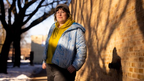Emily Been stands outside her Edgewater apartment on the North Side. She says it will be a struggle to cover the $100 monthly increase in her health insurance premium.