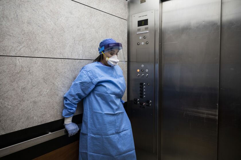 Nurse practitioner Capri Reese takes a minute to herself in an elevator after an 80-year-old man suffering from COVID-19 died at Roseland Community Hospital on the Far South Side, Tuesday afternoon, April 28, 2020. During Reese’s standard 12-hour shift Tuesday, she responded to five code blues and the 80-year-old man was one of three patients to die from the coronavirus.