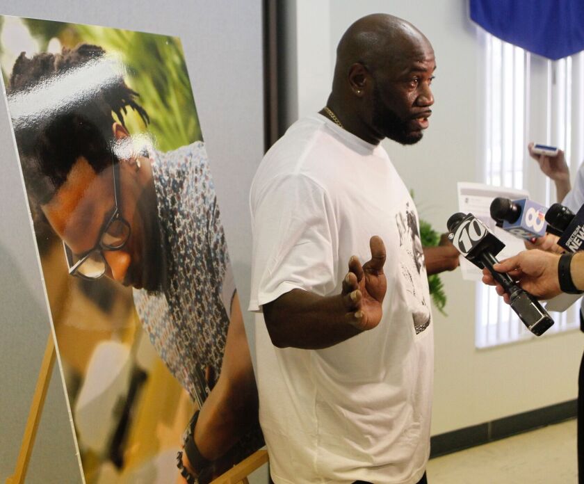 Michael McGlockton, standing in front of a photo of his son Markeis McGlockton, killed in a shooting, speaks at a news conference in Clearwater, Florida., on Tuesday, July 24, 2018. | Jim Damaske/Tampa Bay Times via AP
