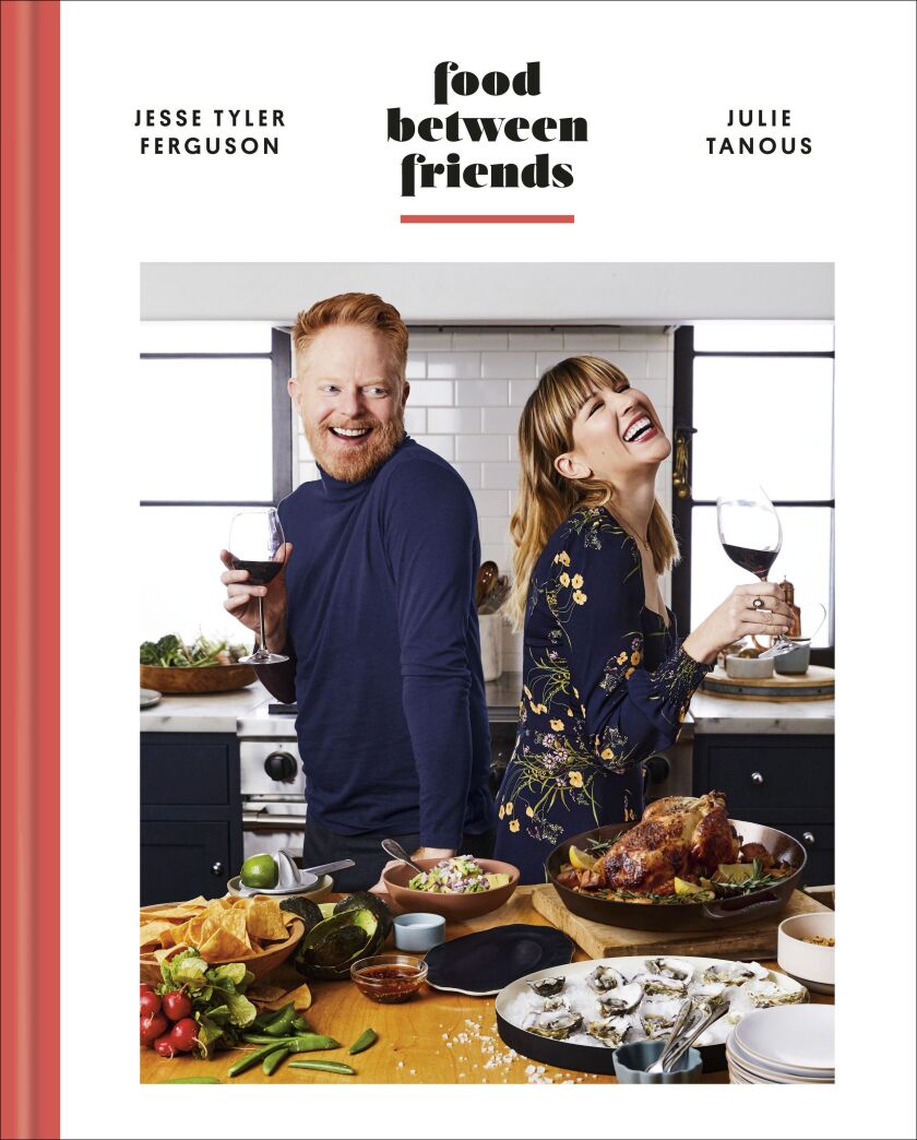 This cover image shows “Food Between Friends” by Jesse Tyler Ferguson and Julie Tanous. (Clarkson Potter via AP)