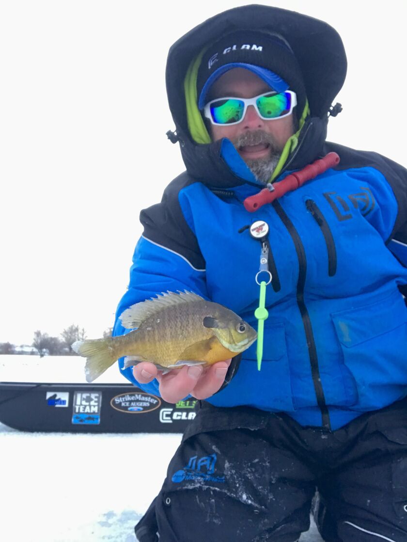 Ken “Husker” O’Malley, holding a bluegill, found fishing success success while checking ice conditions. Provided photo