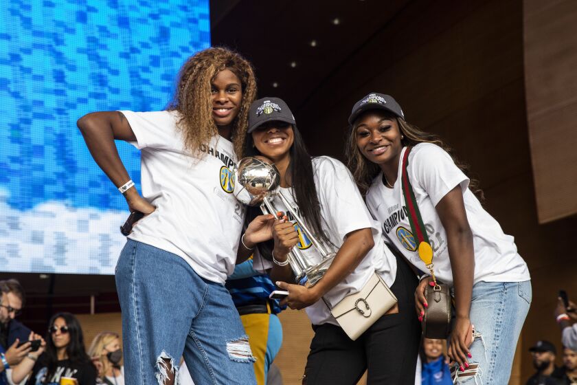 (From left) Ruthy Hebard, Lexie Brown and Dana Evans pose for a photo with the championship trophy.