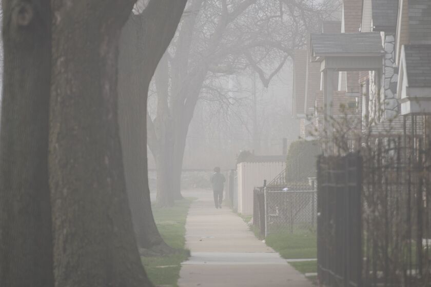 A cloud of dust spreads across the Little Village neighborhood after a smokestack was imploded in 2020
